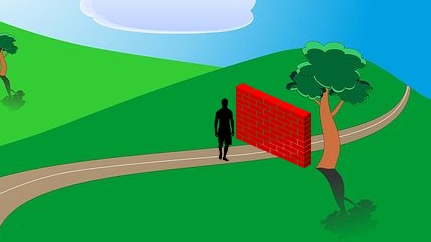 Man walking on road but brick wall is blocking his way.