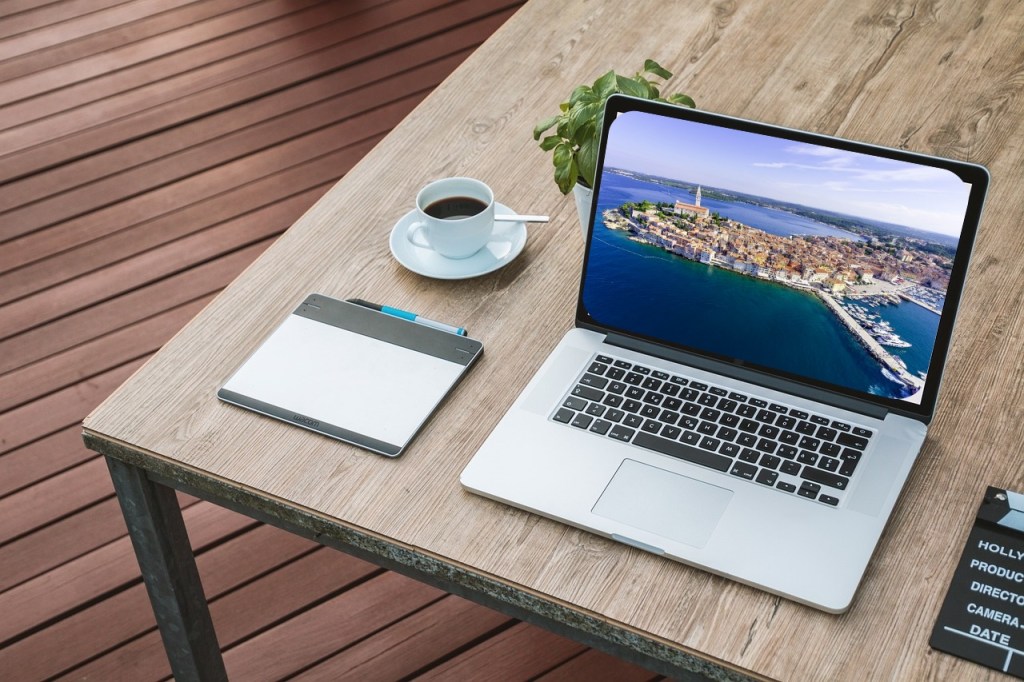 A laptop on a table. Laptop has image of exotic vacation spot