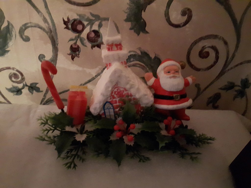 An image of an old Santa's shop decoration with Santa standing outside.